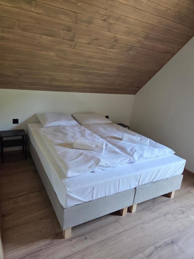 Podwójne łóżko pod drewnianym skosem